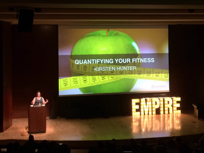 Speaker Kirsten Hunter on stage with the first slide of her talk entitled "Quantifying your Fitness"