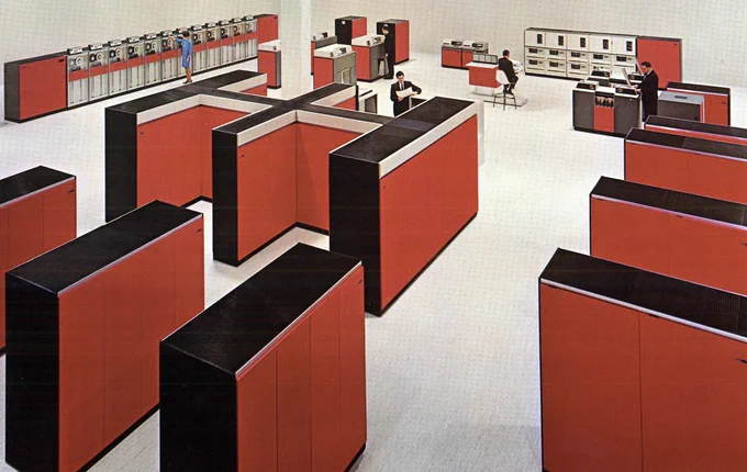 The System 360/Model 85 filled a room. Tape drives, printers, disk drives, and card readers fill the background. In this IBM photo, the computer cabinets are red.