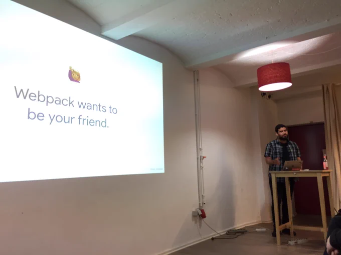 Davi on stage. The slide on the screen says the title of his talk, “Webpack wants to be your friend”.