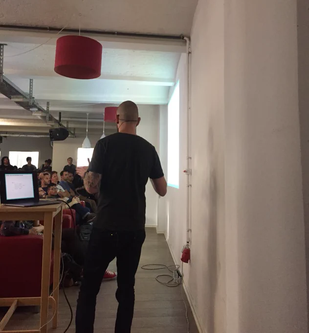 Photo of Nico from behind speaking to the audience.