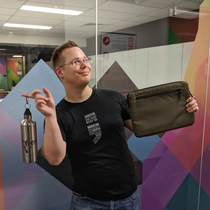 Kevin Vandenbeken poses fancifully with a laptop sleeve and a water bottle