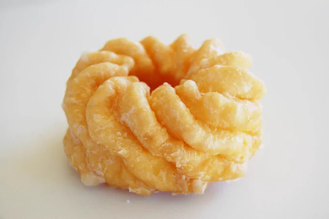 a close-up photo of a french cruller, clearly showing the twisted ridge texture