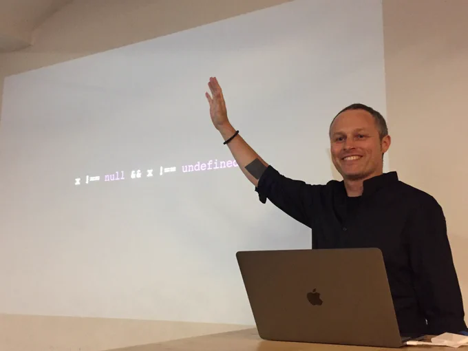 Rudi raising his hand in front of his intro slide.