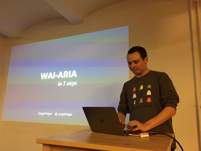 Sergei typing on his computer. In the background is his opening slide “WAI-ARIA in 5 steps”.
