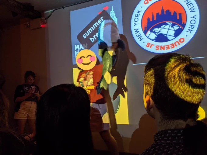 a person on stage holding up a plush shark