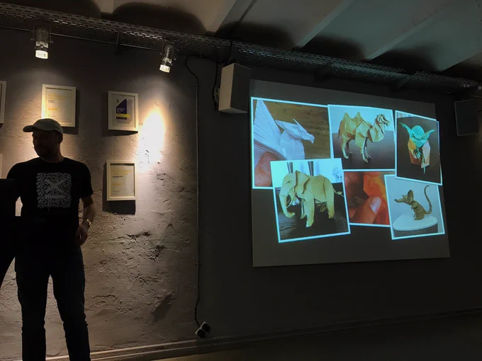 Nils in Front of a slide with photos of origami.