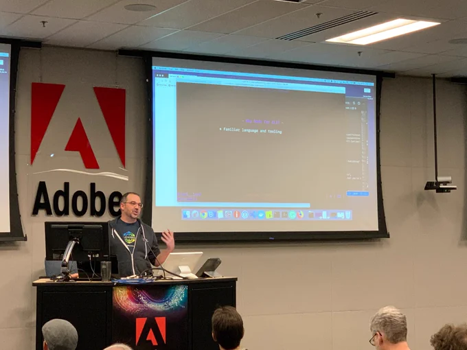 Joel Lord behind a podium presenting a tech talk.