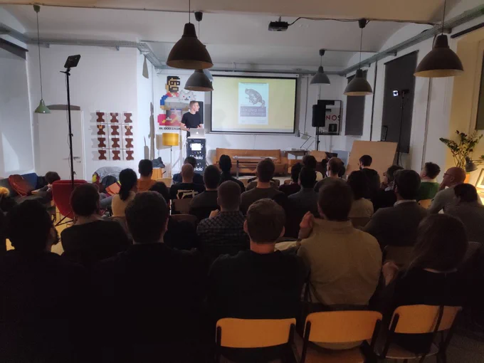 A person giving a talk in front of an audience at a Meetup