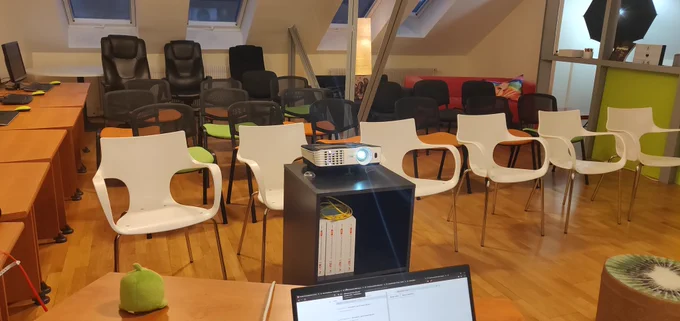 A room with chairs and a laptop ready to talk in front of people :)