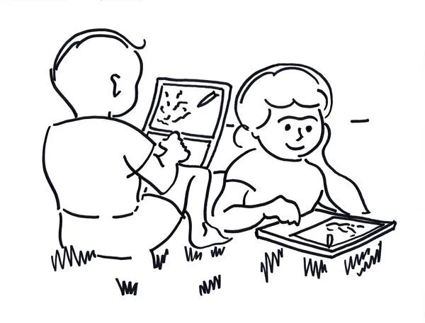 Two kids outside on grass using Alan Kay’s Dynabooks