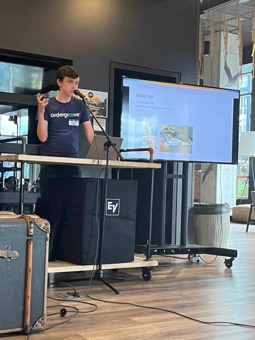 Geoff presenting on SvelteKit, in front of a table with his right hand raised