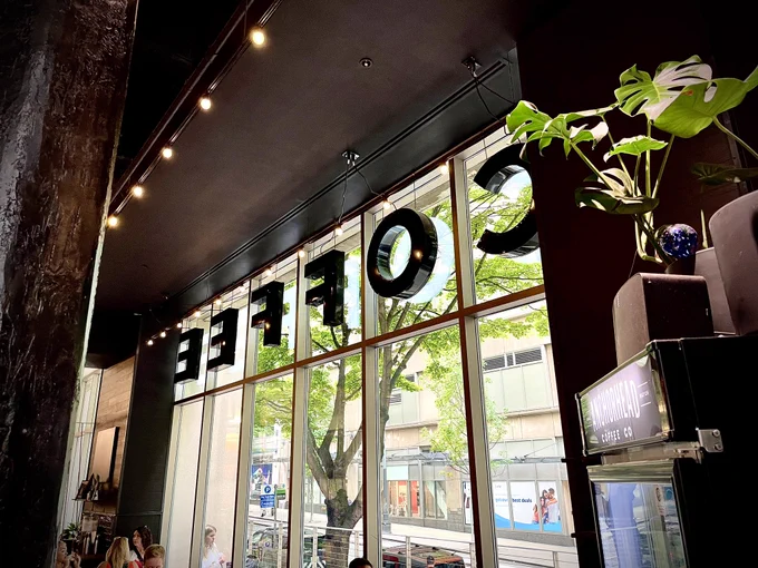 the interior of Anchorhead Coffee, showing windows with large letters spelling “coffee” in them