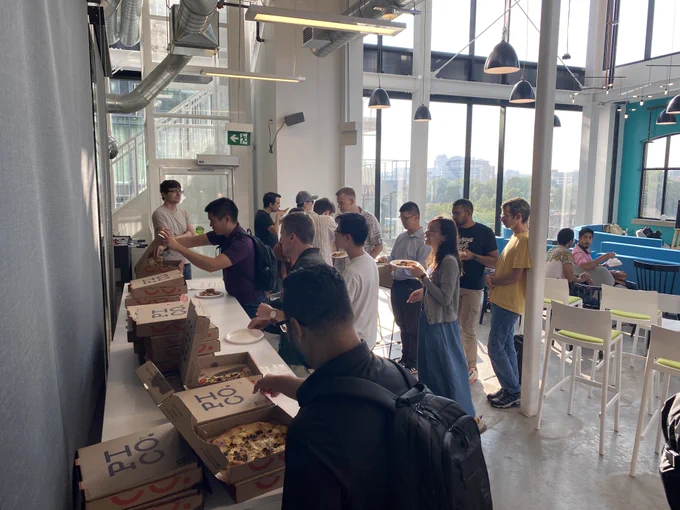 A crowd of community members lined up to grab some pizza