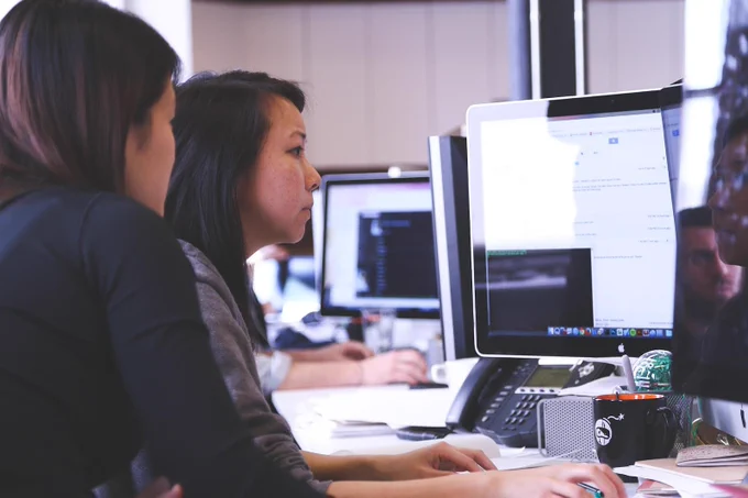 This is a photo of two high school students on a computer. 