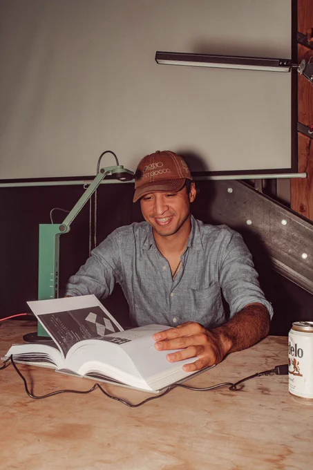 An image of someone flipping through the community catalog book. They are smiling and holding the thick book on a wooden table.