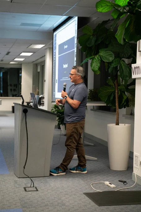 A side shot of Nik LeBlanc presenting his talk on "DORA at DevCycle: Tracking engineering metrics that matter".