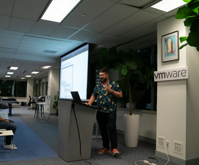 A wide shot of Rob Jackiewicz at the podium using his laptop to lead a mob programming session