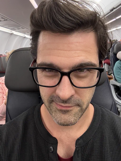 A selfie of me sat down in my seat on a plane