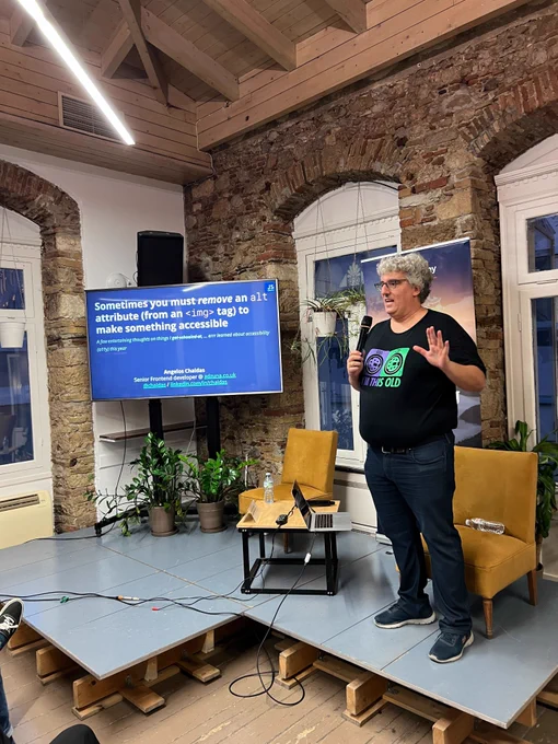 Angelos Chaidas on the stage of the GreeceJS meetup presenting: This year I learned: Sometimes you must remove an "alt" attribute from an "img" tag to make something accessible. 