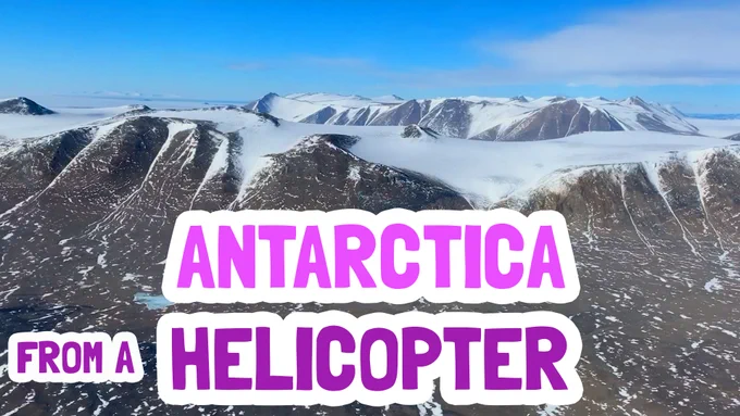 Snow-covered mountains with the title Antarctica from a helicopter.