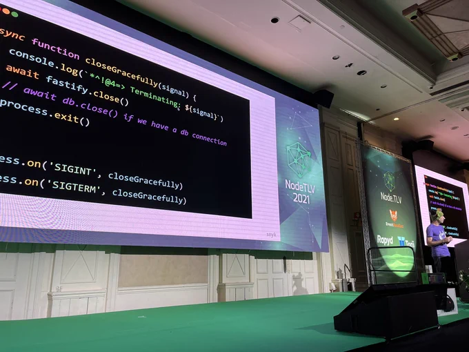 Picture of Liran speaking about Docker and NodeJS with a screenshot of a Fastify process on screen