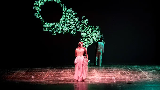 Scena di teatro con personaggi di spalle. Fondale digitale con elementi fluidi e organici che si spostano. 