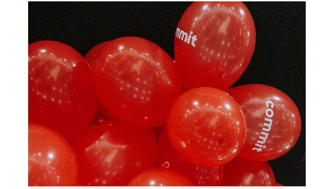 Imagen de unos globos rojos con el logo de Commit