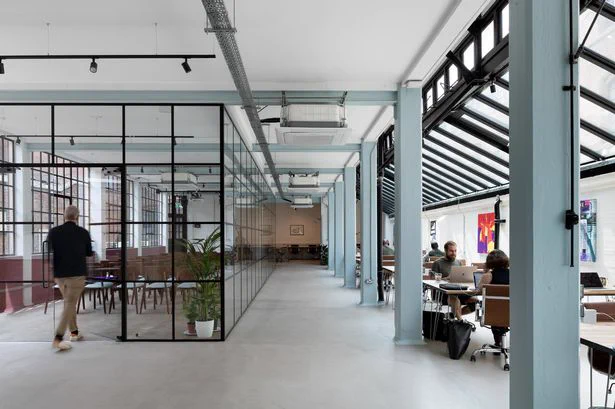 The Jointworks co-working space, someone walking into a room and people working at desks