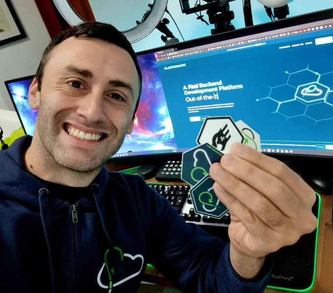 Francesco with the Platformatic hoodie holding 3 platformatic stickers and a fastify sticker