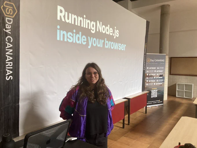 I’m standing in front of the screen with the first slide from my talk - “Running Node.js inside your browser”, near a JSDay Canarias banner. I am half-smiling.
