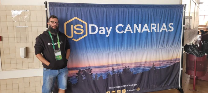 Foto en la que aparezco de pie junto a una pancarta del JSDay Canarias 2023