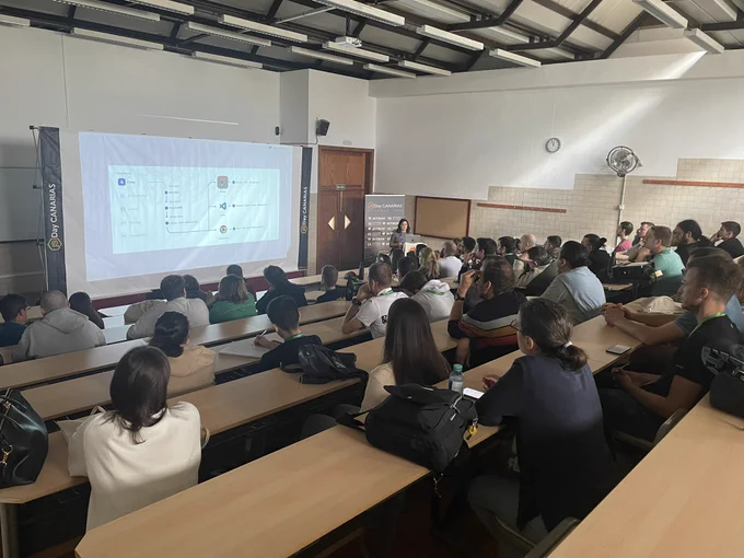 Elena Coazzoli giving a talk at the JSDayCanarias and a room full of people listening to the talk.