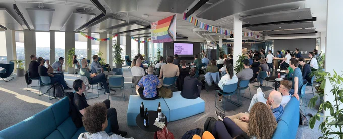 Elena Coazzoli giving a talk at the Vienna React Meetup and a room full of people listening to the talk.