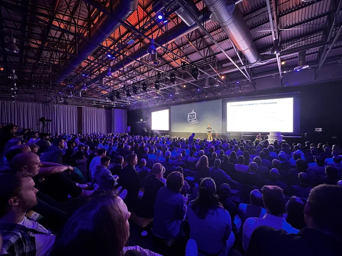 The audience and stage of the Nordic.js conference, in blue/pink mood