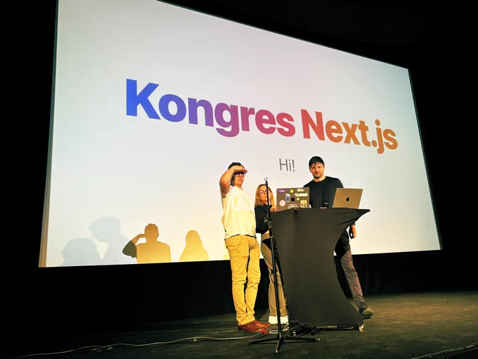 The conference stage with Michal looking into the future, standing next to Aleksandra and Zaiste.