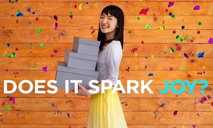 Marie Kondo holding boxes, saying: 'Does it spark joy?'